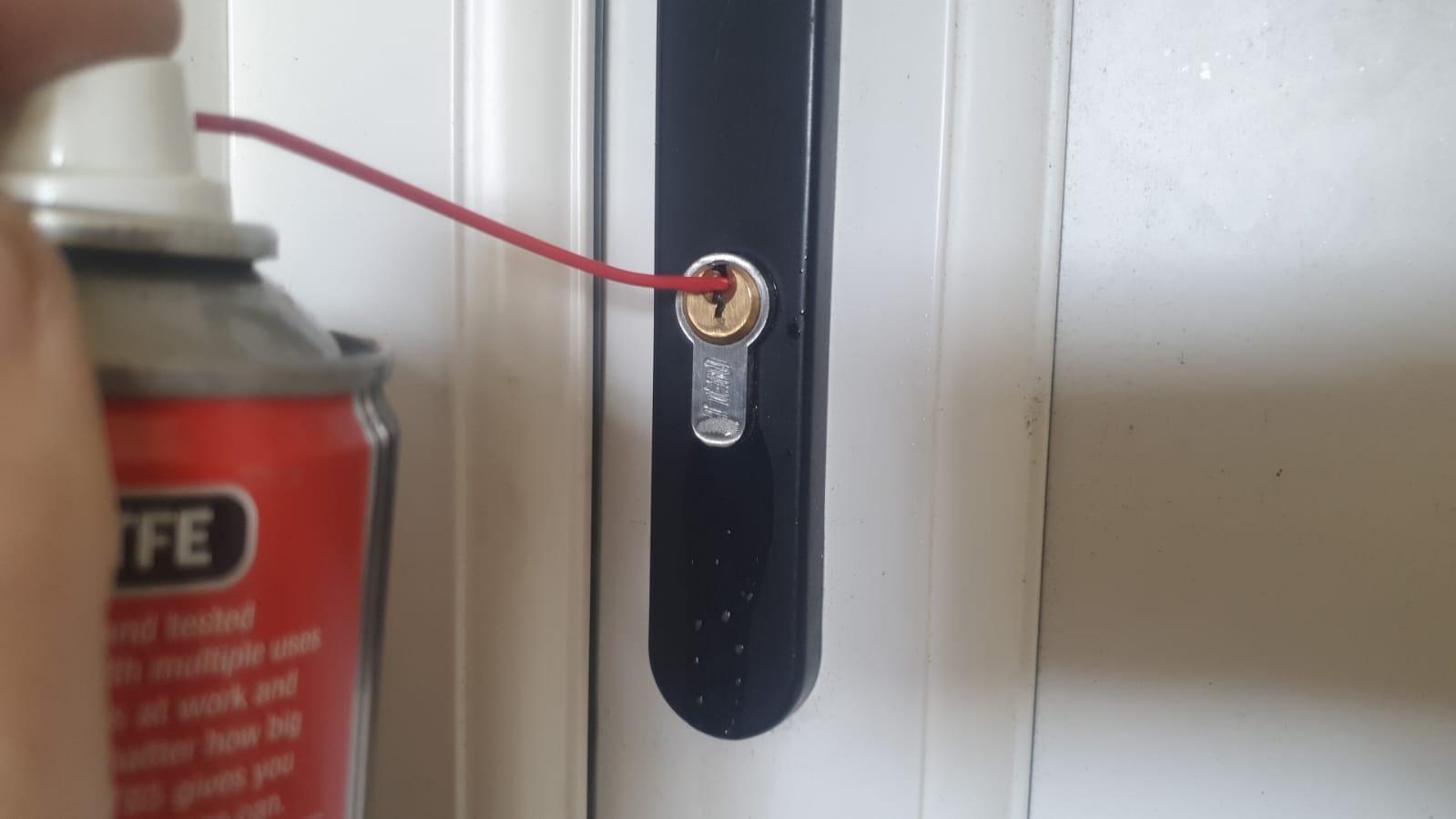 Image shown of  Locksmith lubricating a lock