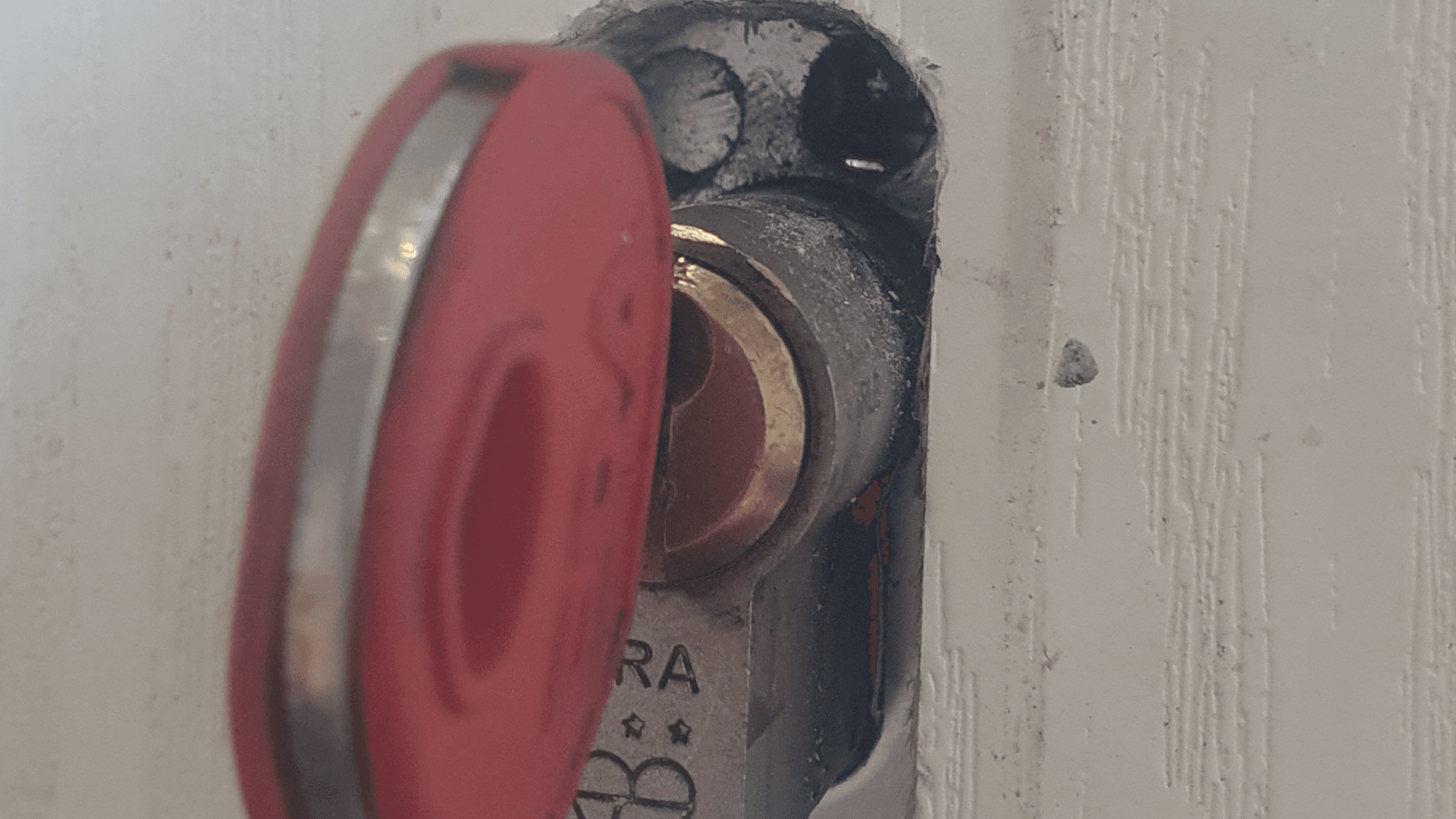 Close-up of strategic drilling point for non-destructive entry on composite door lock