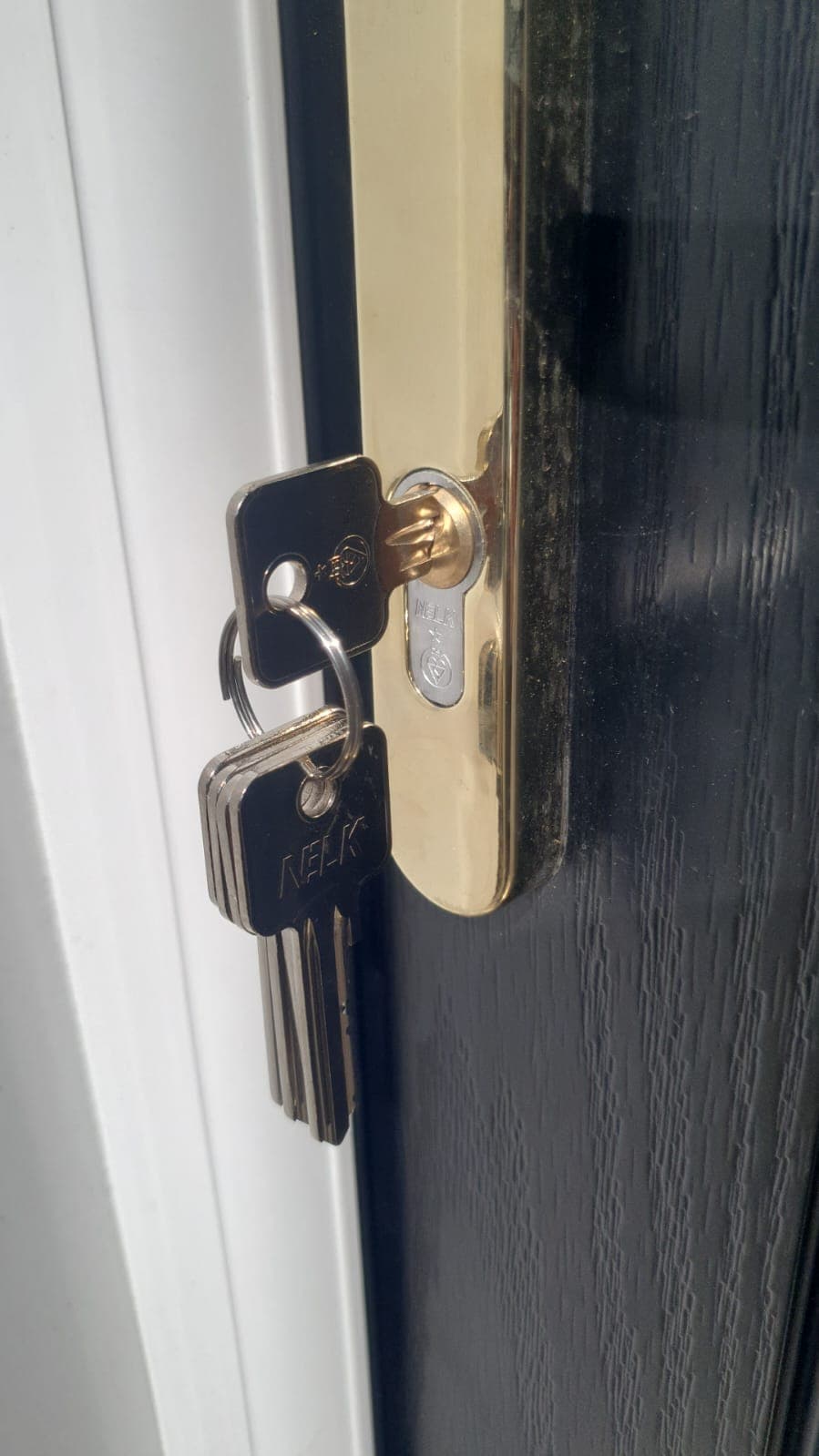 A new euro cylinder fitted to a black composite door with keys