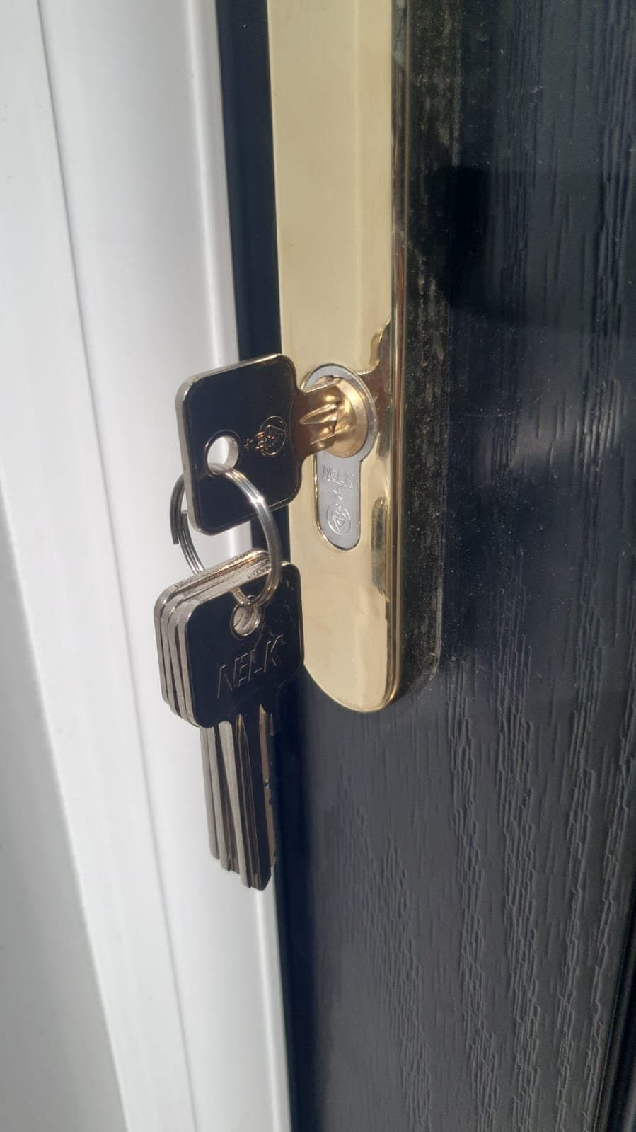 A new euro cylinder with keys fitted to a dark front door