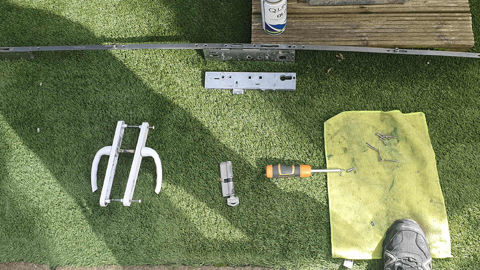 A uPVC door multipoint lock strip, handles and euro cylinder laid out during a lock change